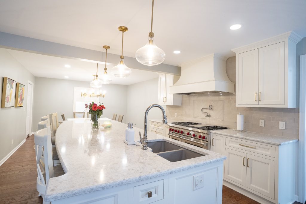 luxury remodeled kitchen with a large long white island counter and cabinets