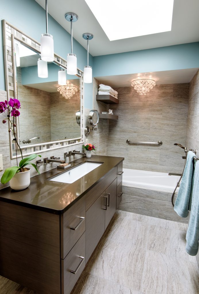 Elegant bathroom with chandelier and large vanity.