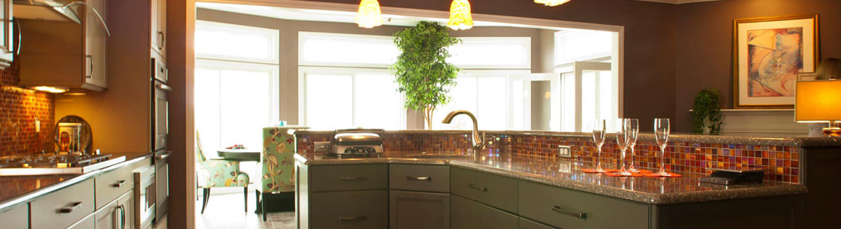 Green cabinets and a red tile give off elegance in this kitchen remodeling project