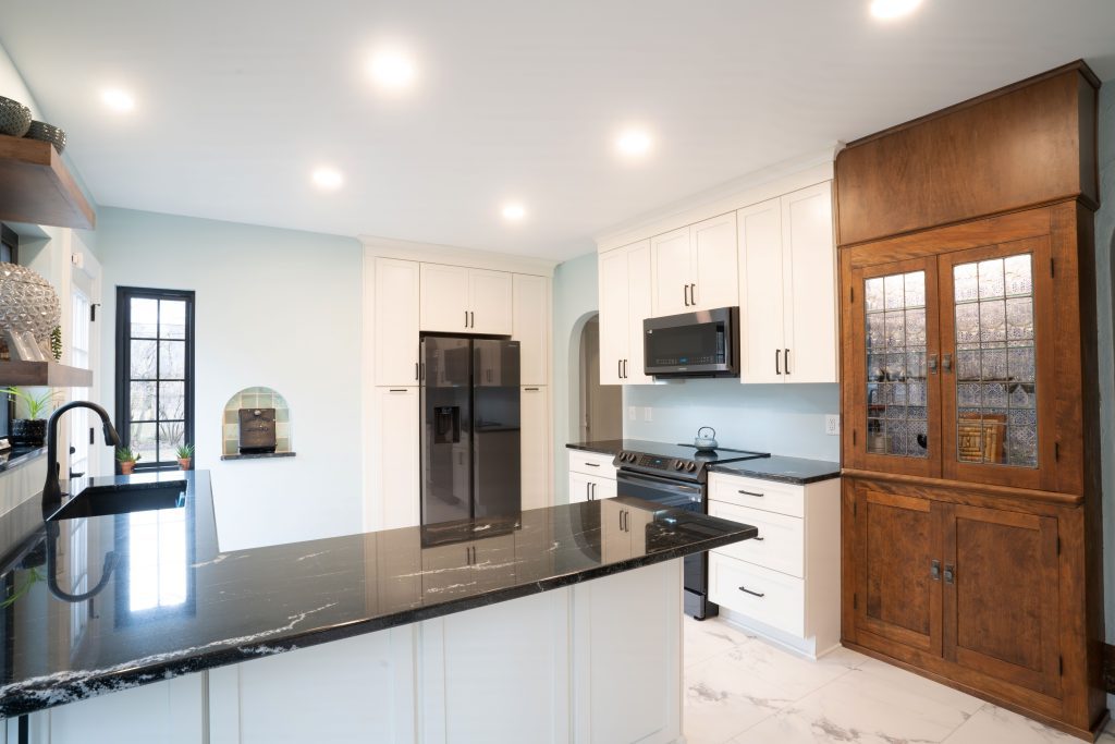 White kitchen with black countertops. Modern design and built in storage solution.