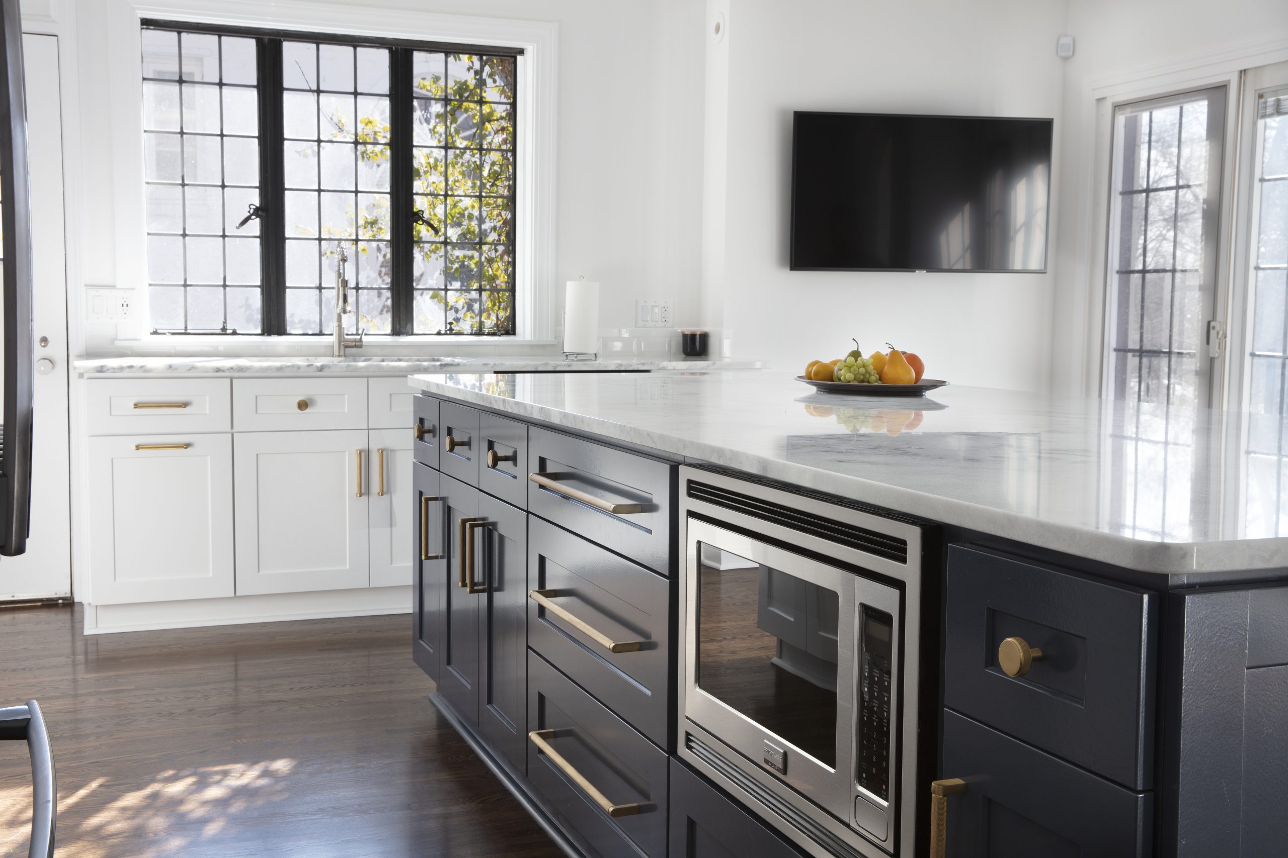 Recently renovated kitchen with updated appliances built into a large island.