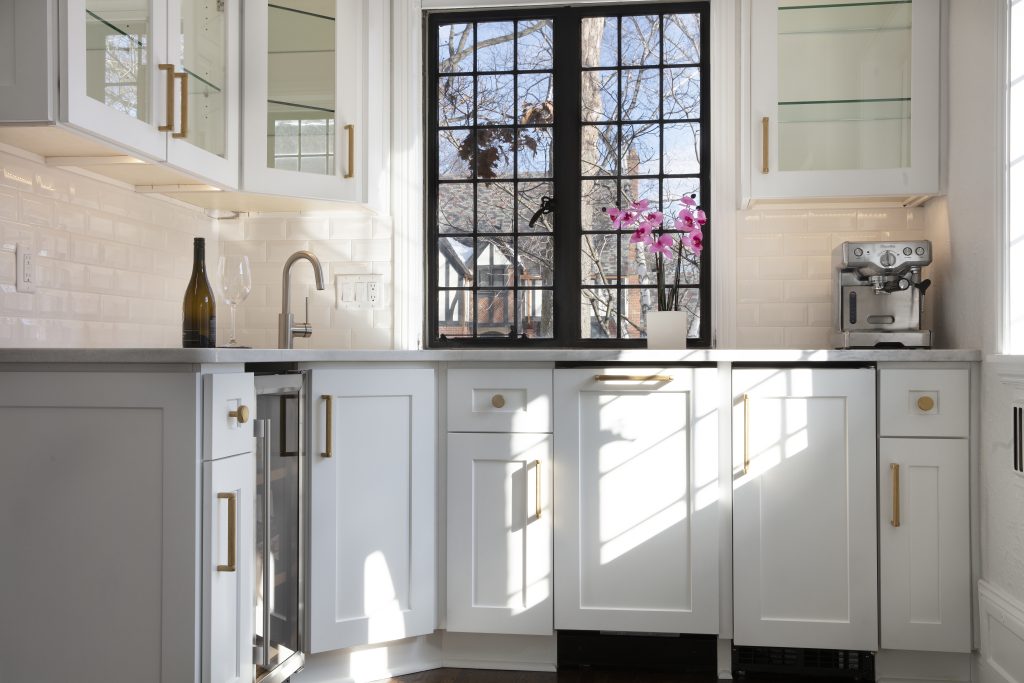 White kitchen cabinets with marble countertop in a recently remodeled kitchen. 