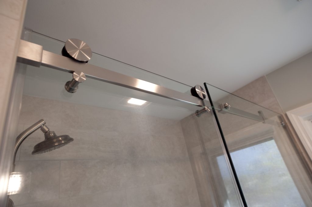 Renovated bathroom with spa like shower head and sleek glass doors. 