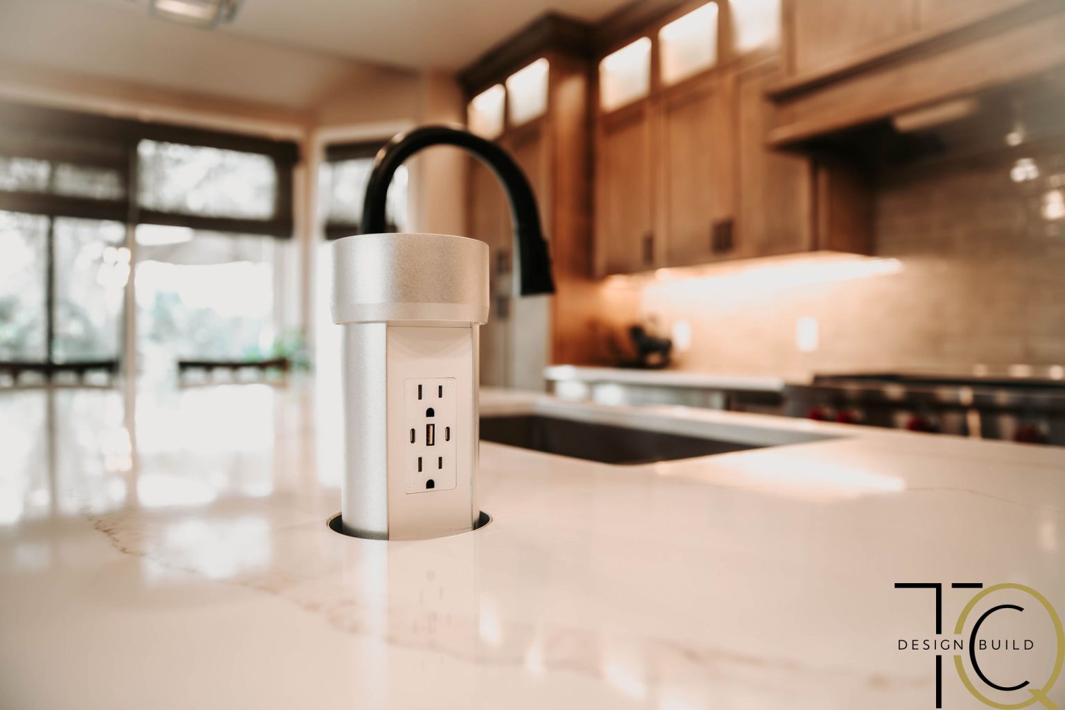 Retractable outlet built into Monclova kitchen island countertop for convenient and hidden access to power.