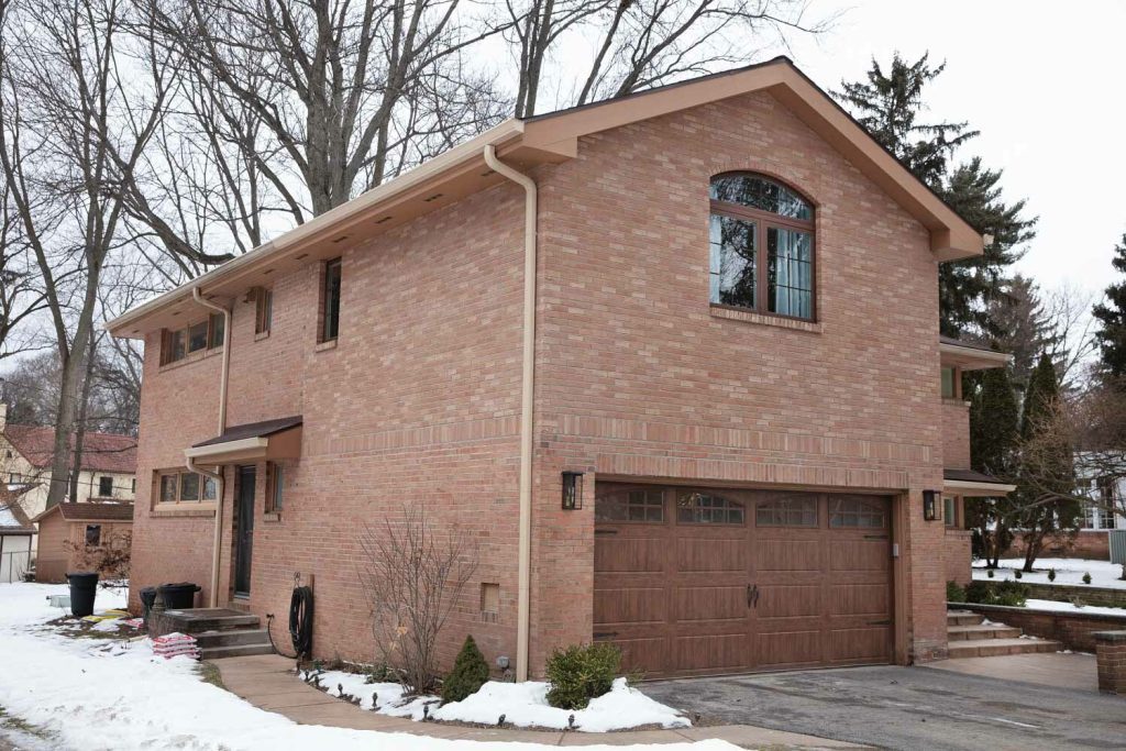Red brick two story home with a recently built garage addition over the garage.