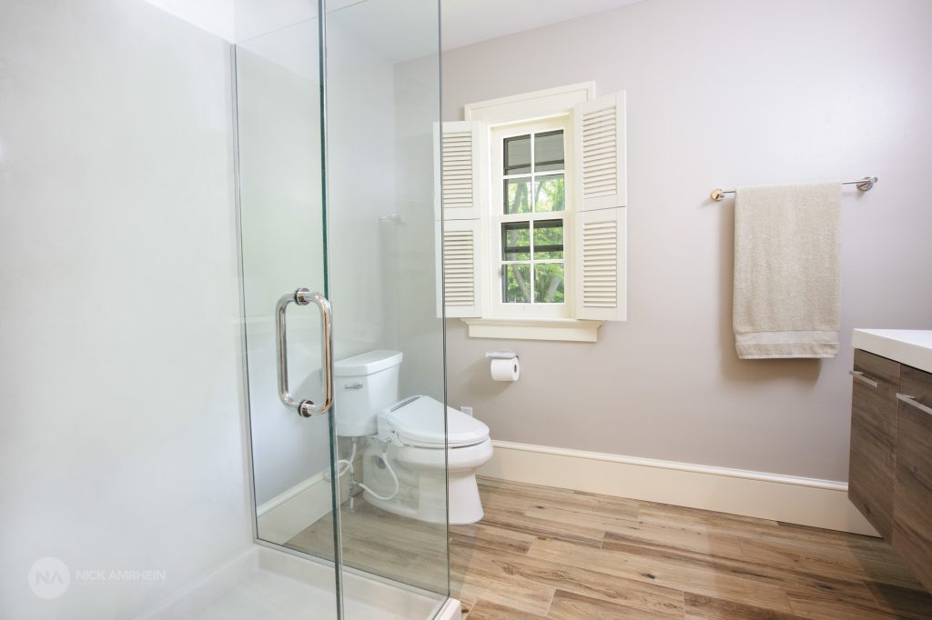 Recently renovated bathroom with new flooring and a glass walk in shower. 