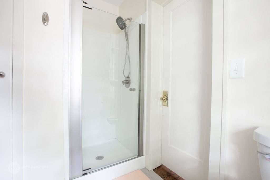 Clean, modern bathroom with white walls and a walk in shower 