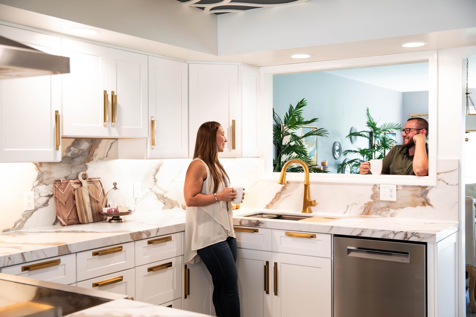 Woman staring out cut out window in her recently renovated kitchen