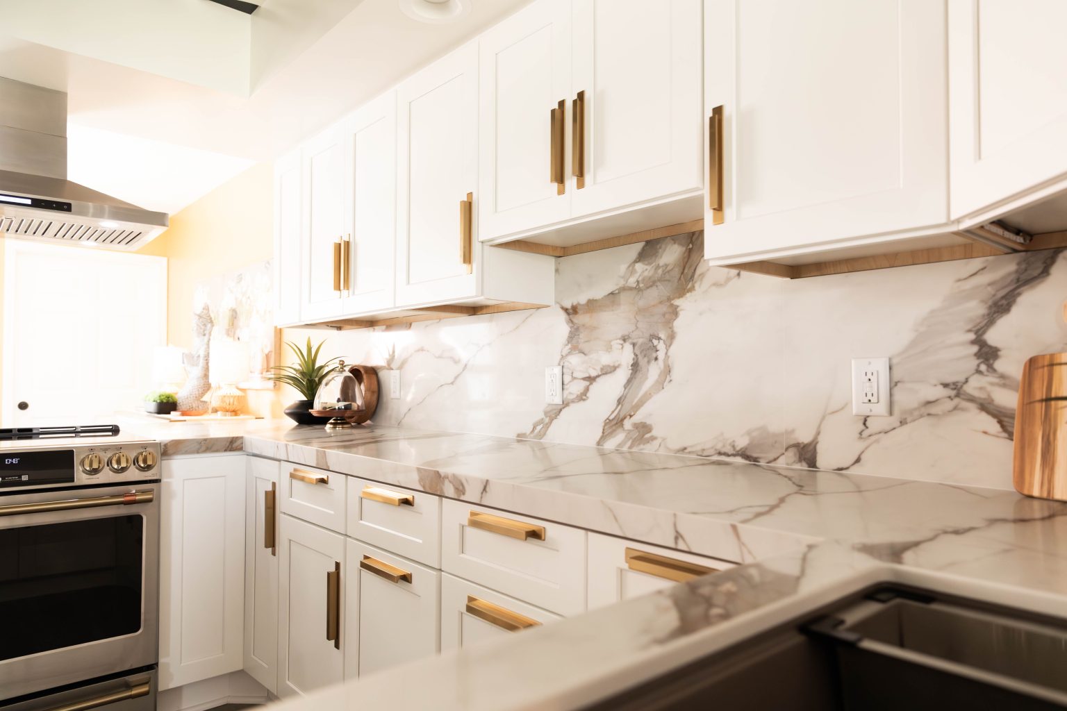 Closeup of recently renovated white kitchen cabinets with gold hardware.