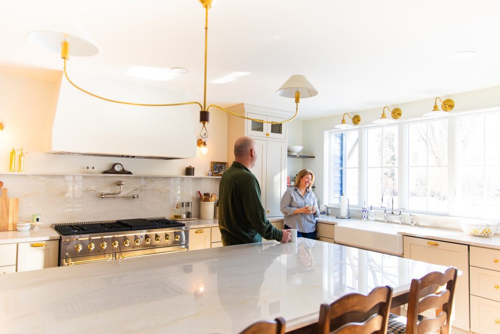 Couple enjoying their recently renovated kitchen with large island. 