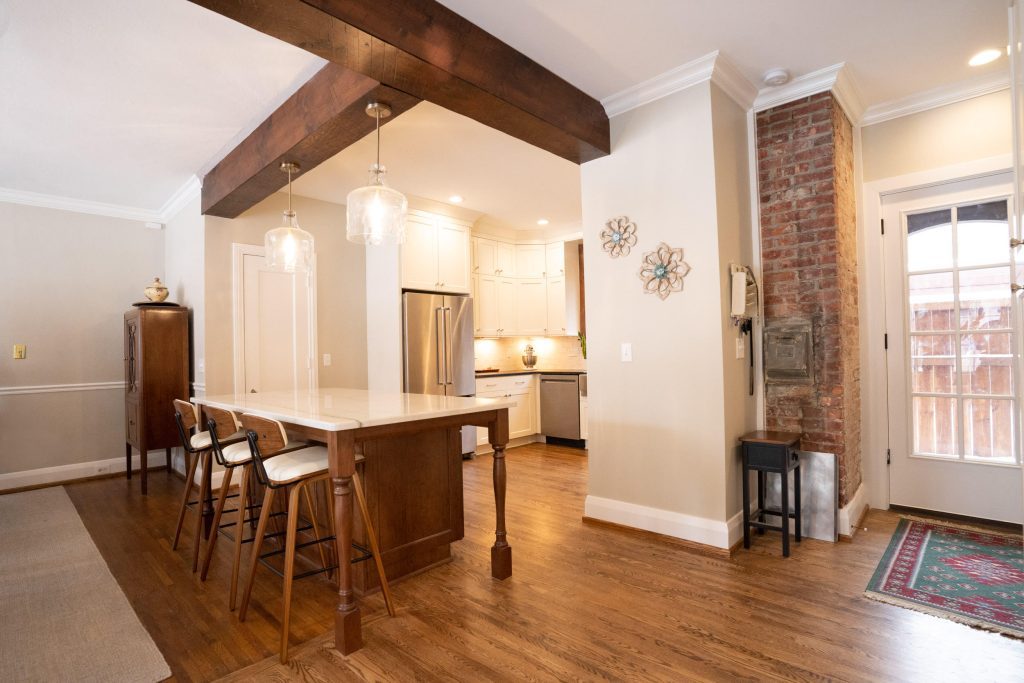 Open concept kitchen with wood beams and dark cabinets. 